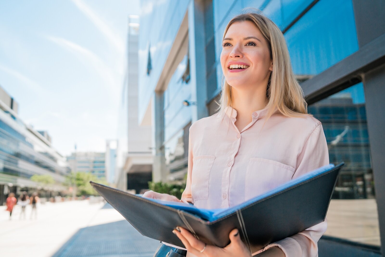 portrait-young-business-woman-holding-clipboard-while-standing-outdoors-street-business-concept.jpg