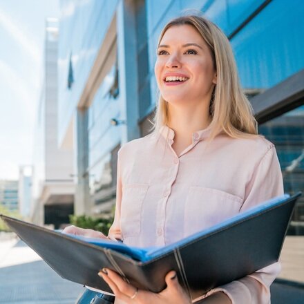 portrait-young-business-woman-holding-clipboard-while-standing-outdoors-street-business-concept_s.jpg